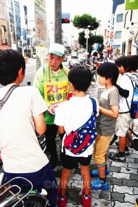 戦争法案反対署名行動で、子どもたちと対話する男性＝６日、大阪市西成区内