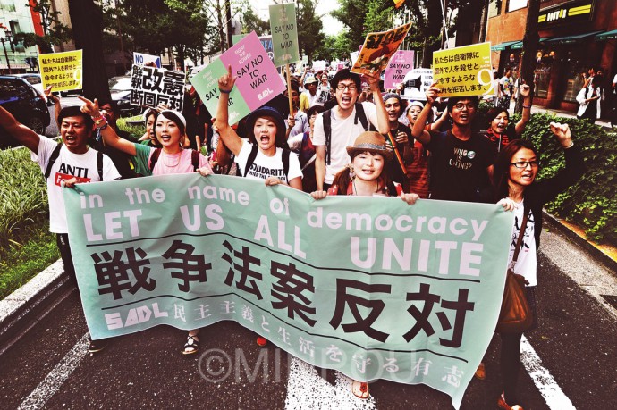 “廃案に追い込むまで声を上げ続ける”。御堂筋をデモ行進する若者ら＝19日、大阪市中央区内