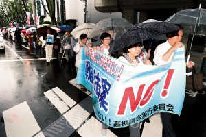 「私たちの力で戦争法案を止める」と、雨の中を歩いてアピールする宮原府議ら（右端）＝４日、高槻市内