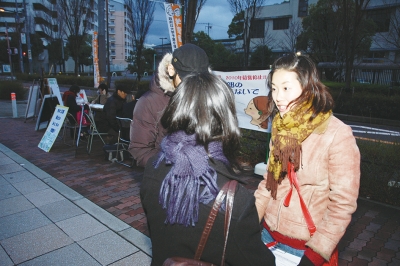 「お金の心配なく学び働ける社会に」と夕闇のなか対話するわたなべさん＝２００９年２月