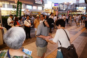 戦争法を廃止し憲法9条を守ろうと署名を集める人たち＝19日、大阪市中央区