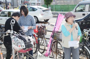     住吉市民病院を充実させる市民の会の署名に応じる親子＝８日、大阪市西成区内