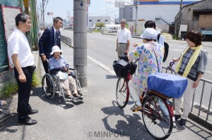 道の真ん中に電柱が立つ国道163号線の歩道を現地調査する日本共産党の清水衆院議員と同党門真市議ら＝20日、門真市内