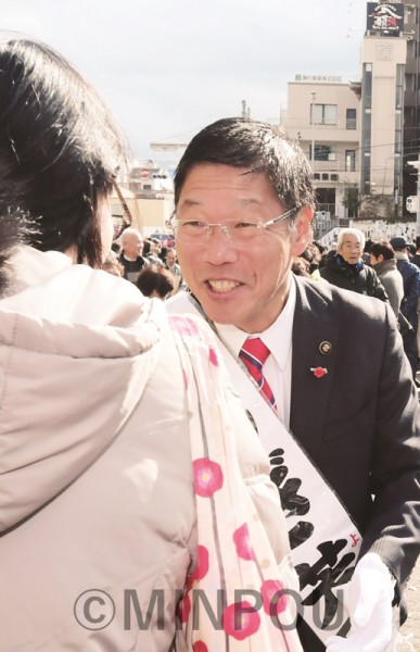 市民と握手する、しぎ芳則候補＝19日、岸和田市内