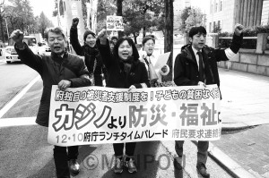 府民連の昼休み集会であいさつする石川府議（中央）と宮原団長（左）＝10日、大阪市中央区内