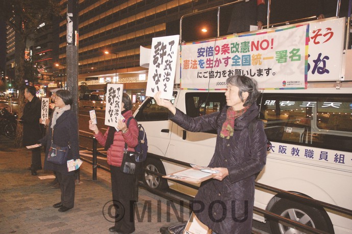 緊急宣伝で「アベ政治許さない」のプラカードを掲げて宣伝する人たち＝10日、大阪市天王寺区内 