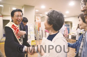 日本共産党大阪二区地区の総決起集会で、参加者と固い握手を交わす山下さん＝19日、大阪市平野区内 