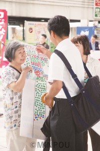 夢洲カジノ万博の賛否を問うシールアンケートをする人たち＝８月30日、大阪市都島区内