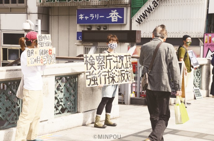 思い思いの言葉を書きこんだプラカードを手に、無言の抗議行動をする市民ら＝17日、大阪市中央区内 