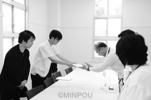 大学側（右）に署名を提出する「考える会」の丸山さん（左から２人目）ら＝16日、大阪市住吉区内