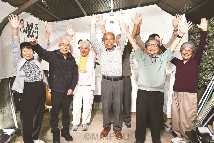 支援者と一緒に初当選を喜び合う高野光一さん（中央）と、36年議員を務めた高尾靖子さん（左端）ら＝９月28日、豊能町内