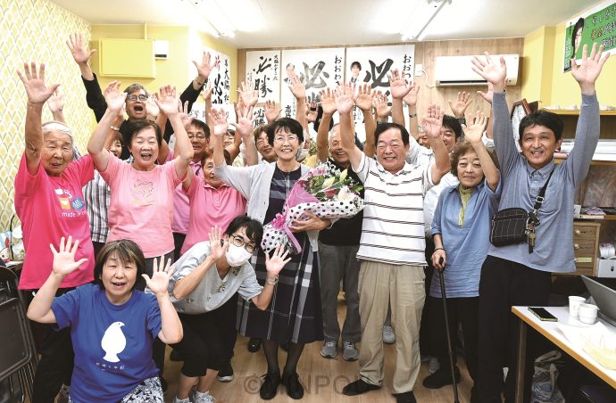 空白克服を果たし、支援者とバンザイを繰り返す大脇和子さん（中央）＝21日、阪南市内