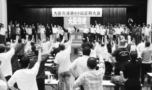  働く者の団結で暮らしと平和を守ろうと〝団結ガンバロー〟を三唱する大会代議員ら＝６日、大阪市中央区内
