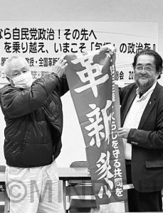 再建総会でのぼりを贈呈する関西学院大学の冨田宏治教授=9日、大阪市平野区内