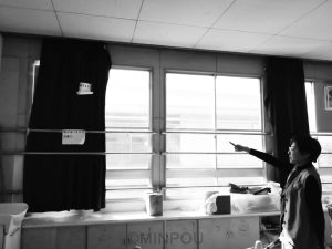 石川議員が指差すカーテンには「窓がありません注意!!」の張り紙が=12日、八尾市内